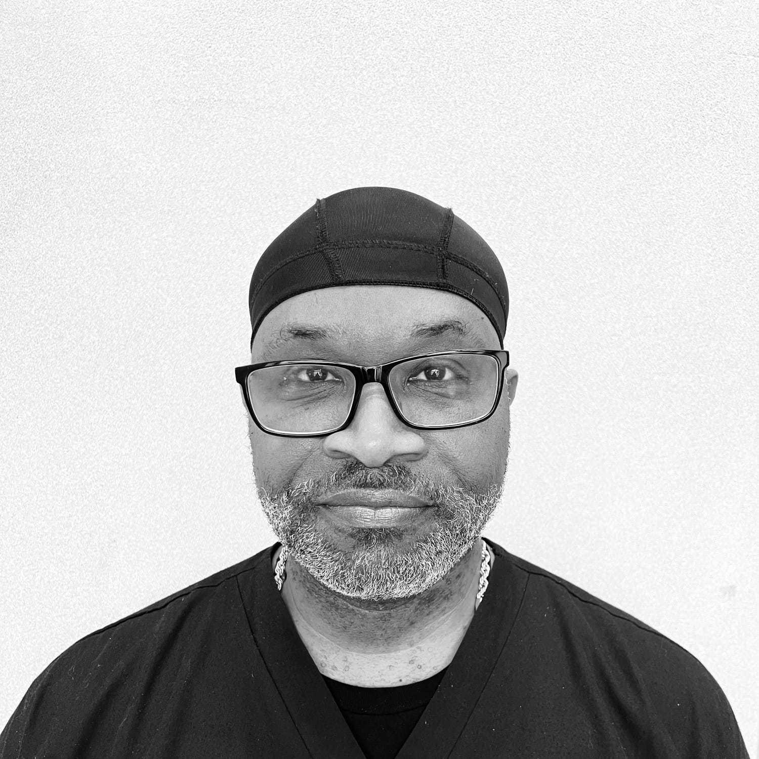 Portrait of Trevor, a professional stylist at The Robert Andrew Salon & Spa Collection, showcasing their expertise and style.