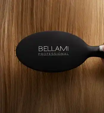Hairbrush labeled "Bellami Professional" on straight blonde hair background.