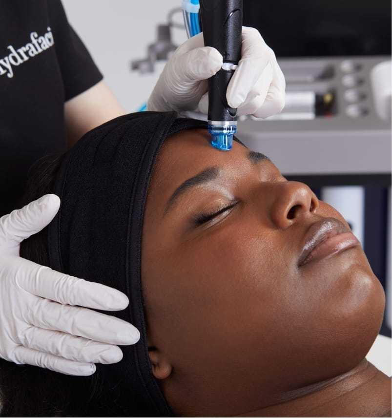 Woman receiving a facial treatment with a skin device.
